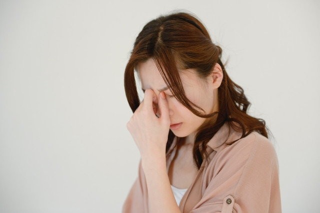 顔を抑える女性の写真